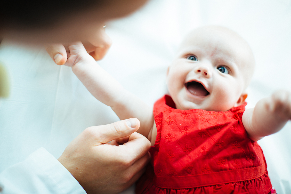 baby smiling with arms open